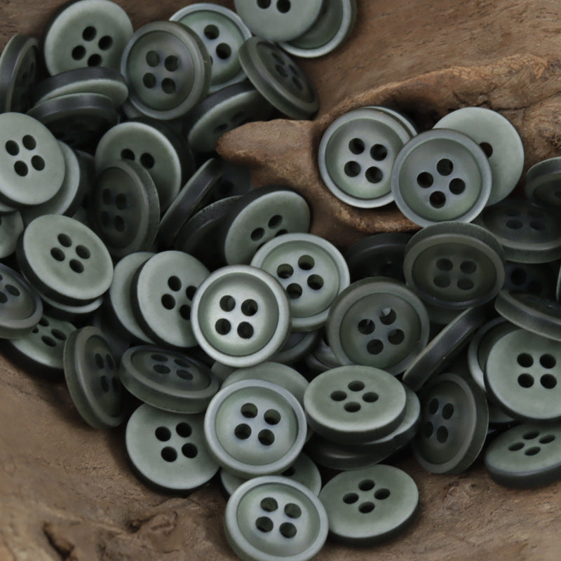 Bulk pile of 11.5mm 4-hole resin buttons in various muted gray-green shades
