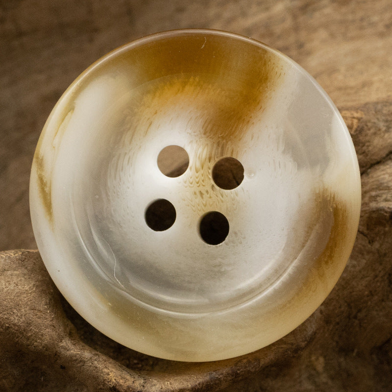 Round 4-hole resin button, light cream with dark hole accents and glossy sheen.