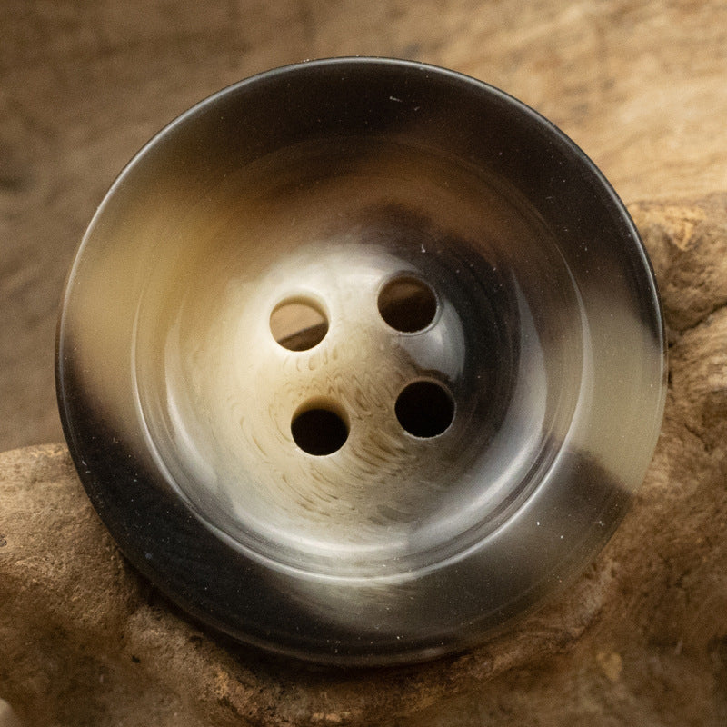 Round 4-hole resin button, dark smoky finish with lighter hole rings.
