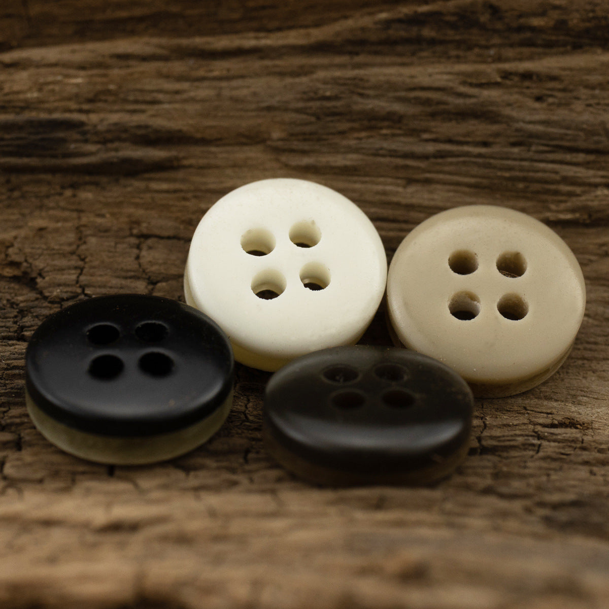 Mixed dark khaki, black, and cream resin shirt buttons with 4 holes on display
