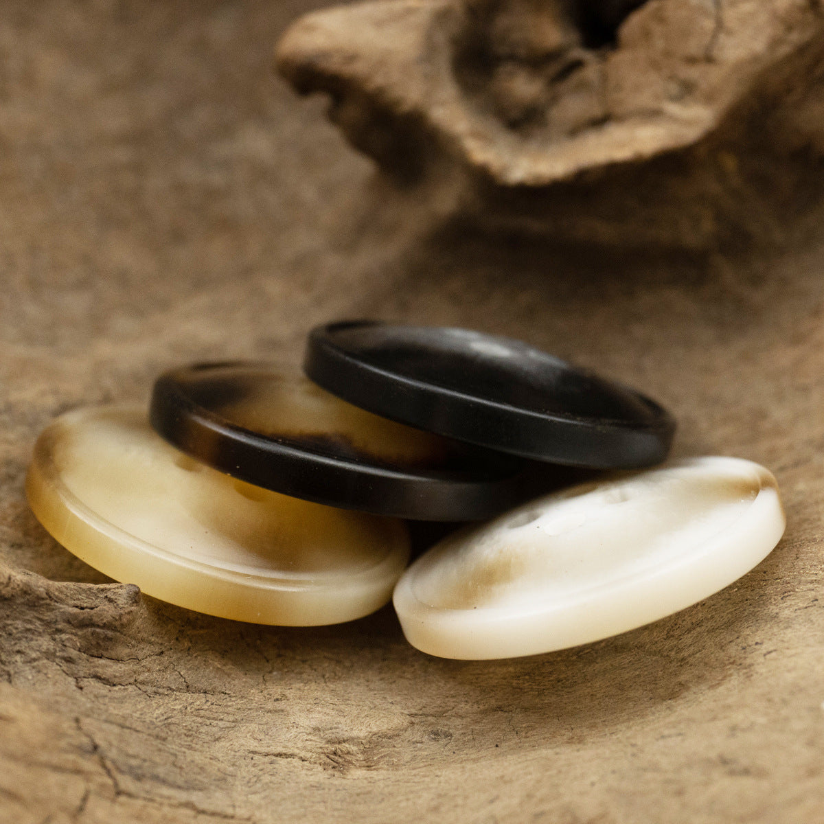 Off-white and dark resin buttons, side-by-side with 2-hole openings
