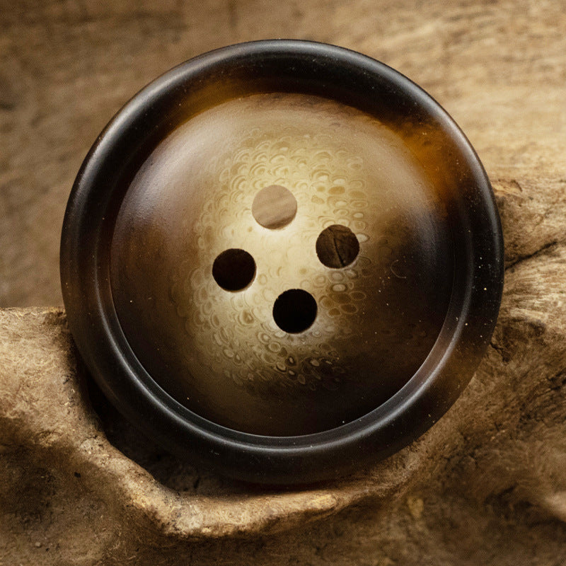 Brown and gold resin button, 4-hole front view with textured sheen