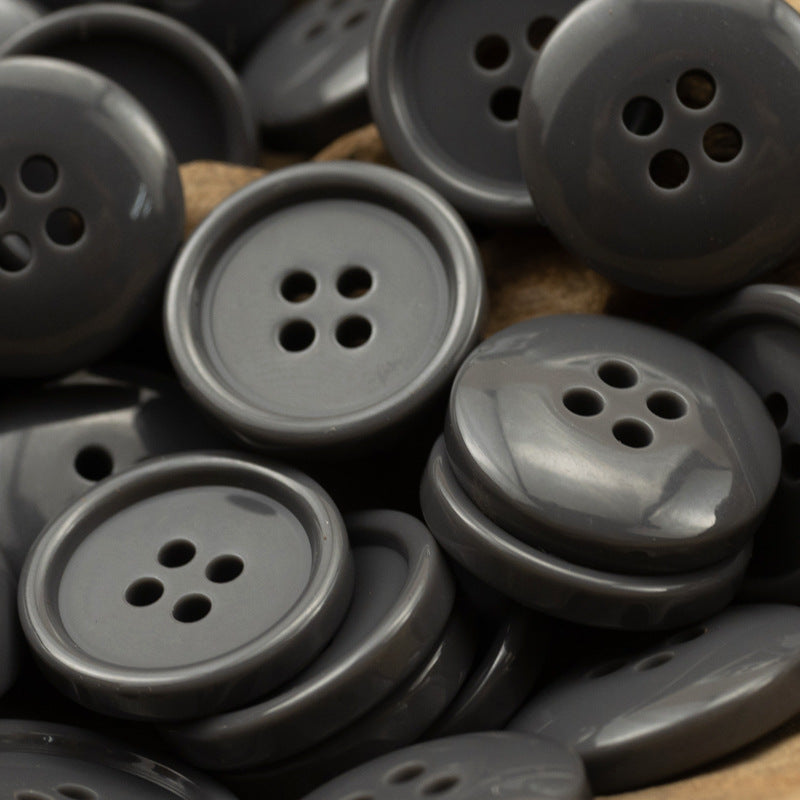 Round four-hole resin buttons in gray and dark charcoal tones