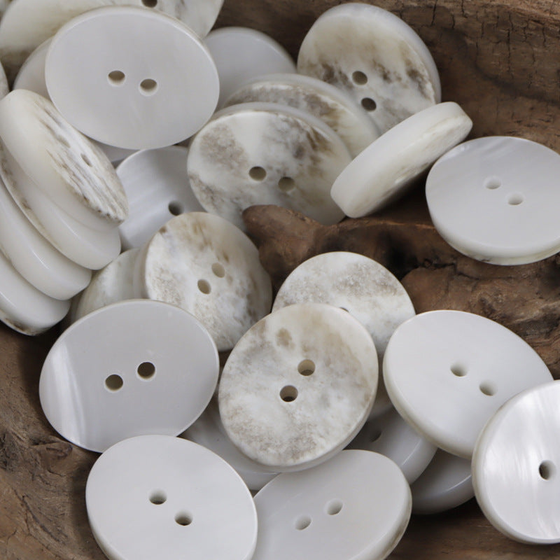 Assorted oval resin buttons in white/cream marble tones with two holes