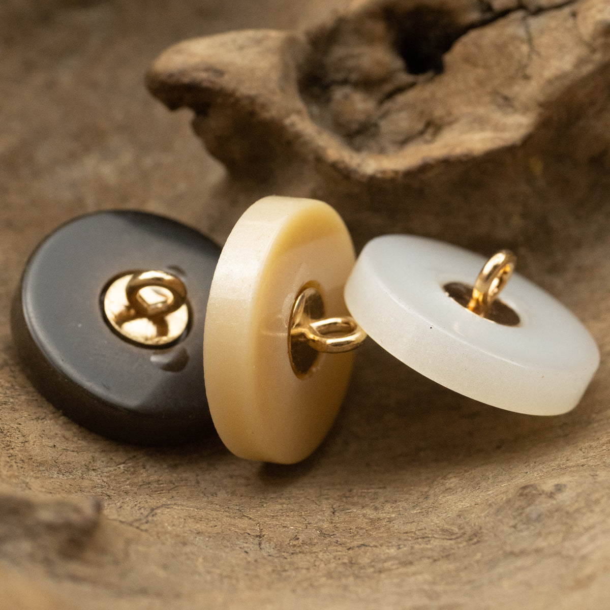 Round frosted resin button pair with metal shanks, one off-white and one dark