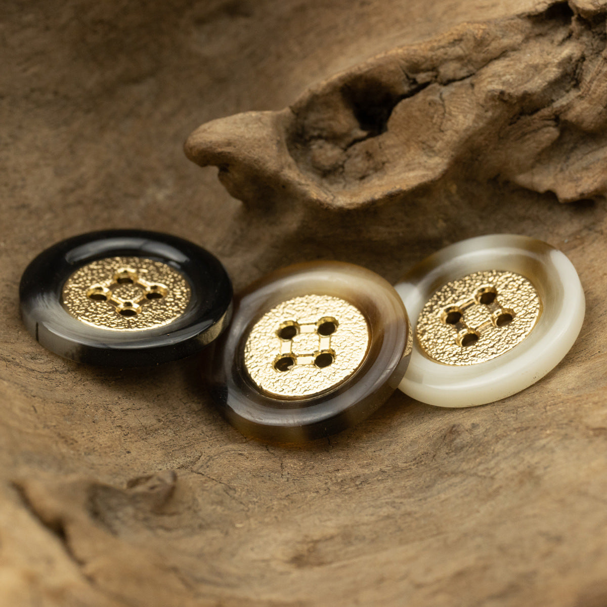 Set of round four-hole resin buttons with gold rims in black, tan and white