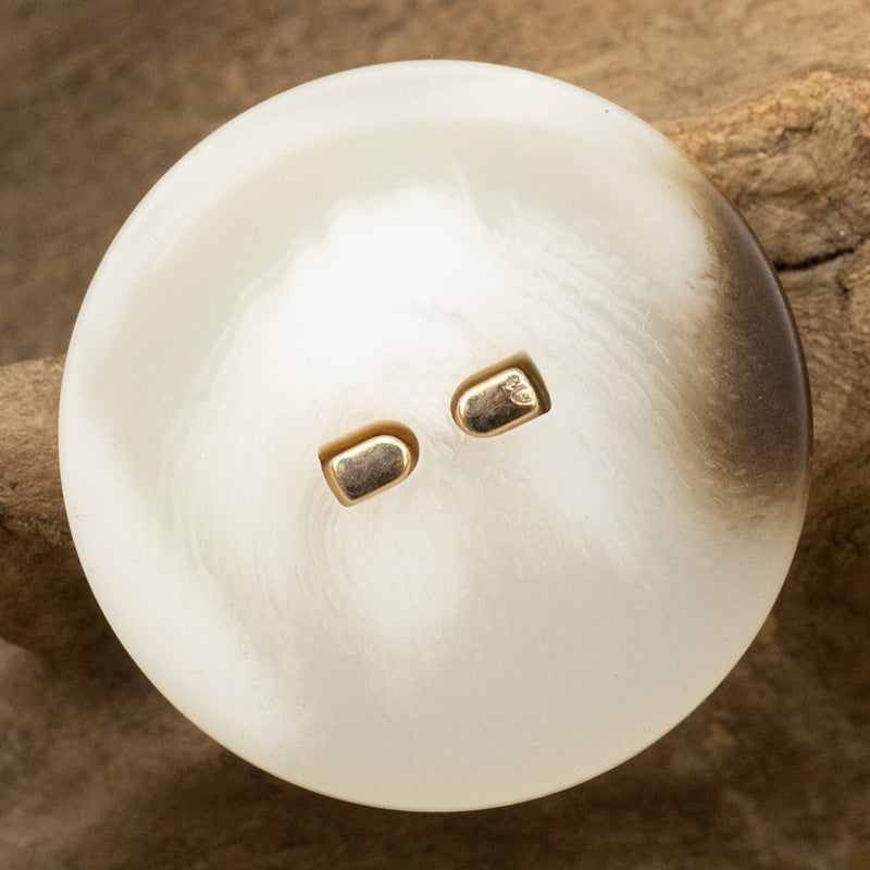Cream flat resin button with metal stem tips, round, two-hole back