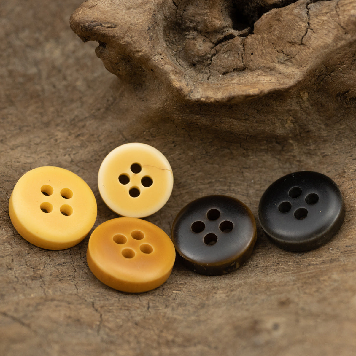 Four resin buttons in orange and dark tones with 4 holes each