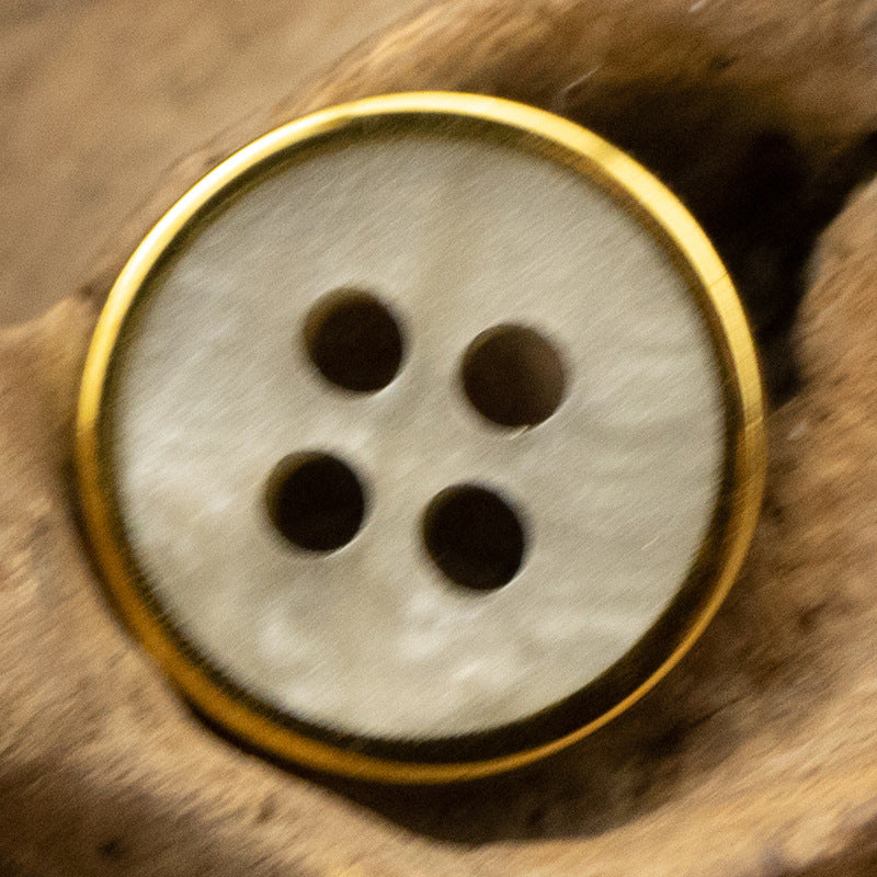 Light gray wood-grain resin button with gold rim, four-hole face
