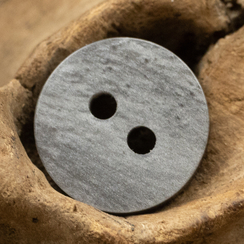 Gray wood-grain resin button with two holes, gold-toned rim edge