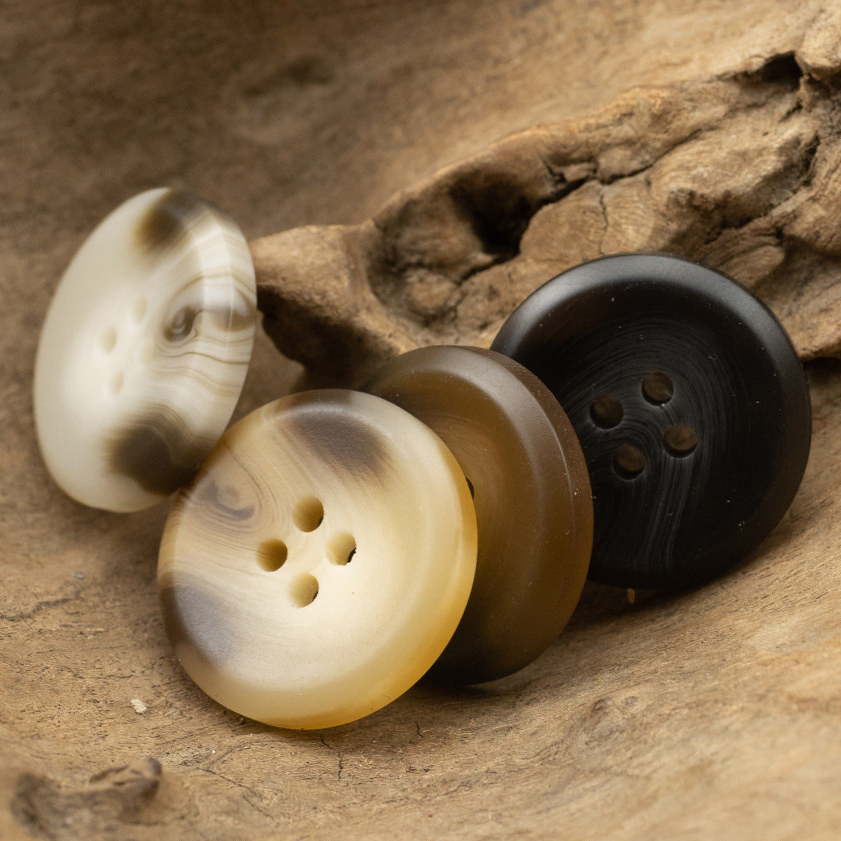 Cream, tan, and dark resin buttons with four holes, round 15–30 mm