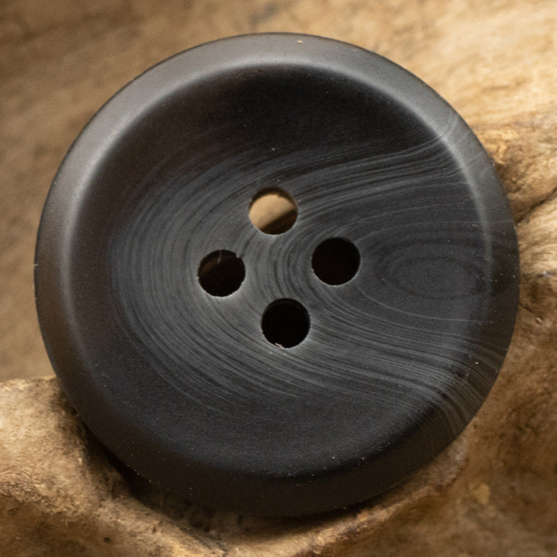 Dark resin button with four holes, round 15–30 mm, matte finish