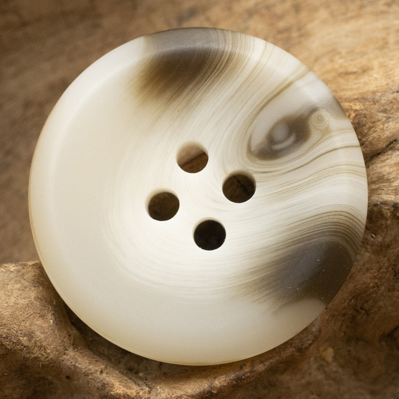 Light cream resin button with four holes and swirl pattern, 15–30 mm