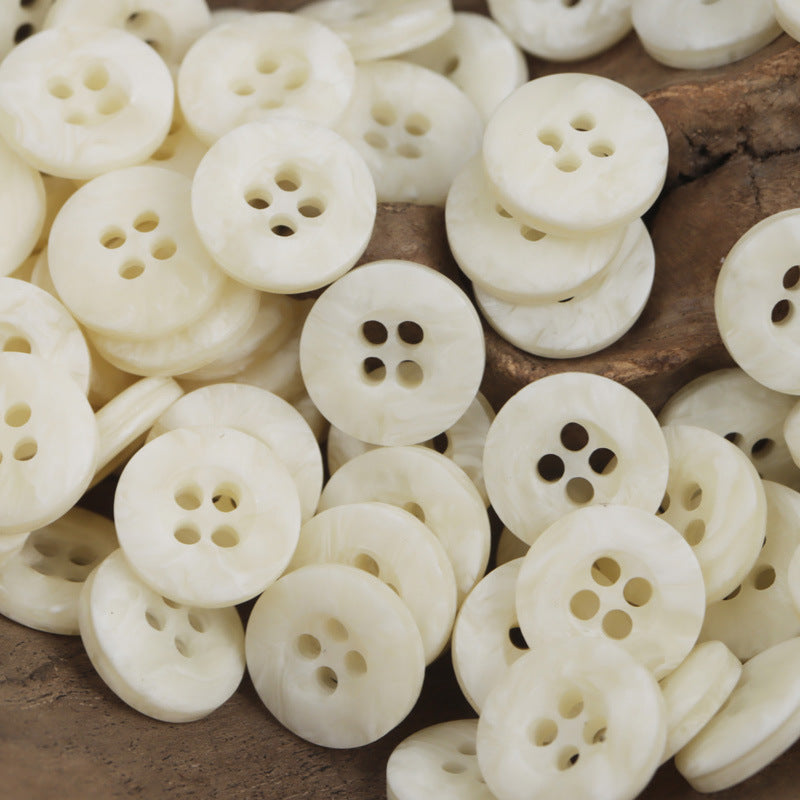 Cream resin buttons with four holes, subtle marbled pattern, bulk pile