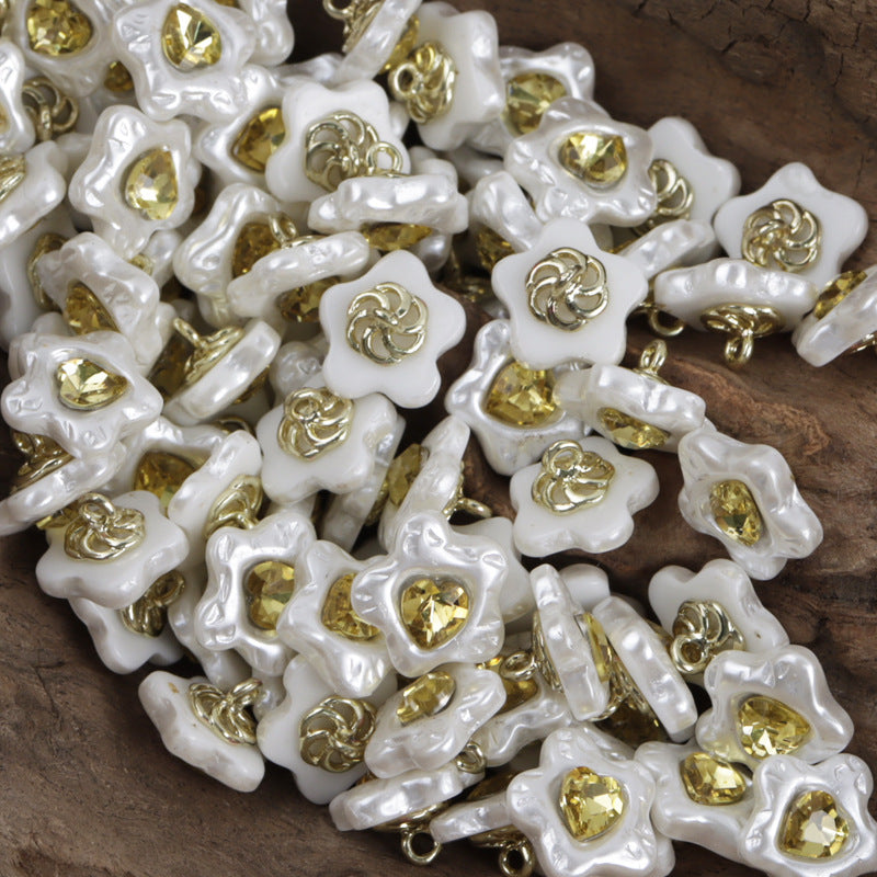 Resin button, star-shaped face, gold-tone jeweled center, metal shank