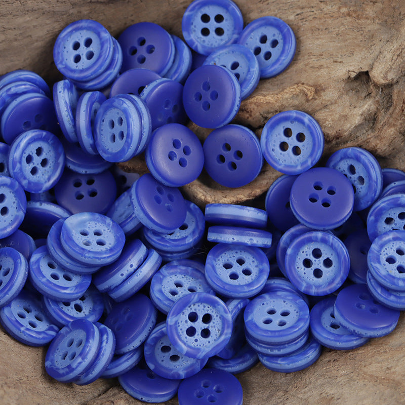 Blue resin four-hole buttons with two-tone pebble pattern, mixed sizes in a pile