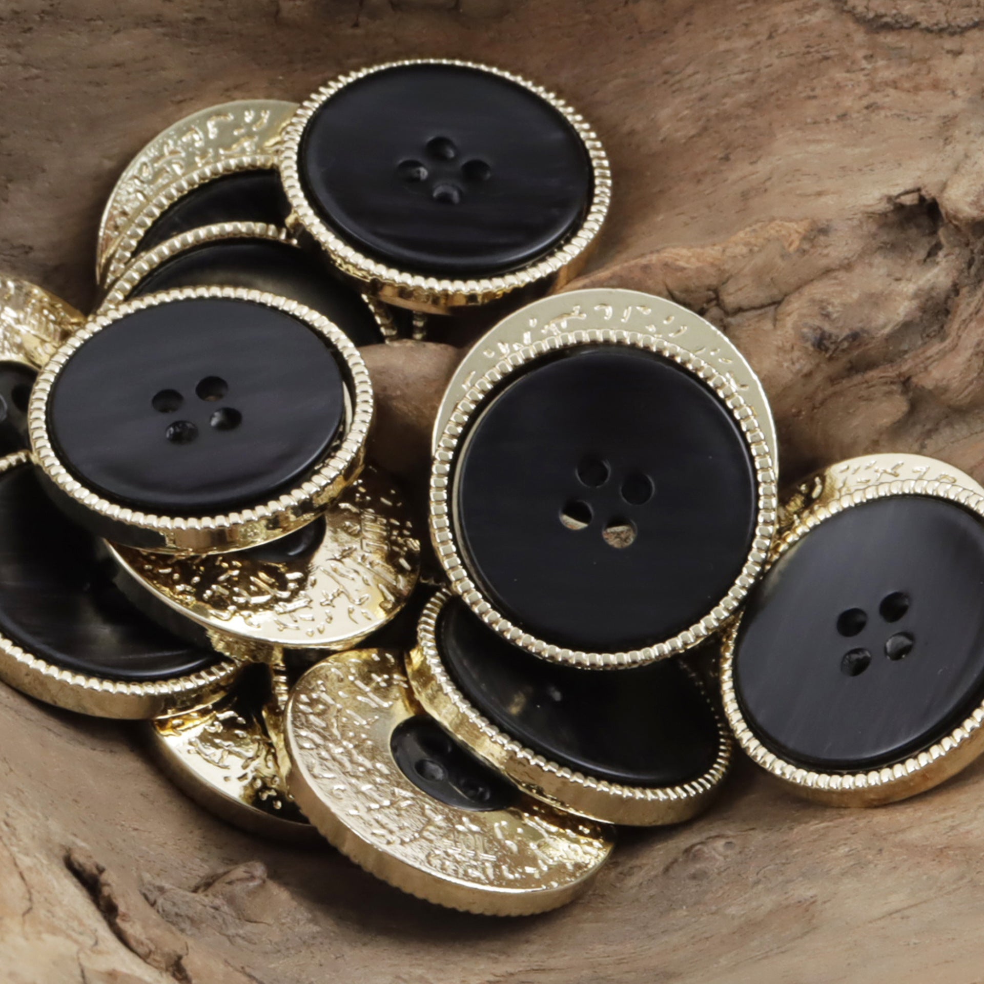 Double-sided two-tone buttons, black resin faces with gold textured rim and 4-hole design