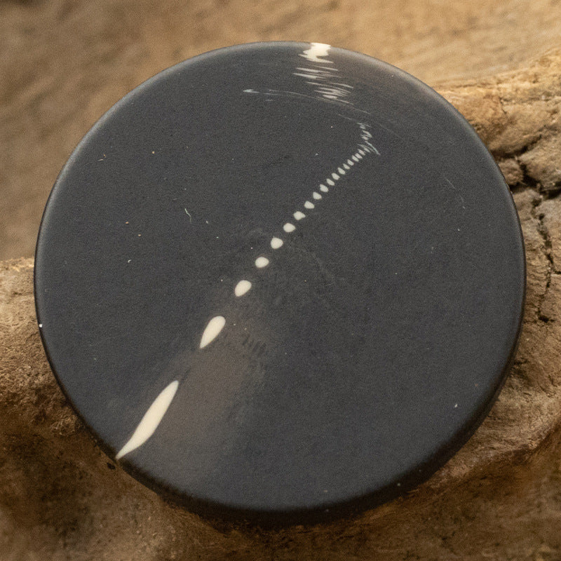 Black flat resin shank button with water-speckle design