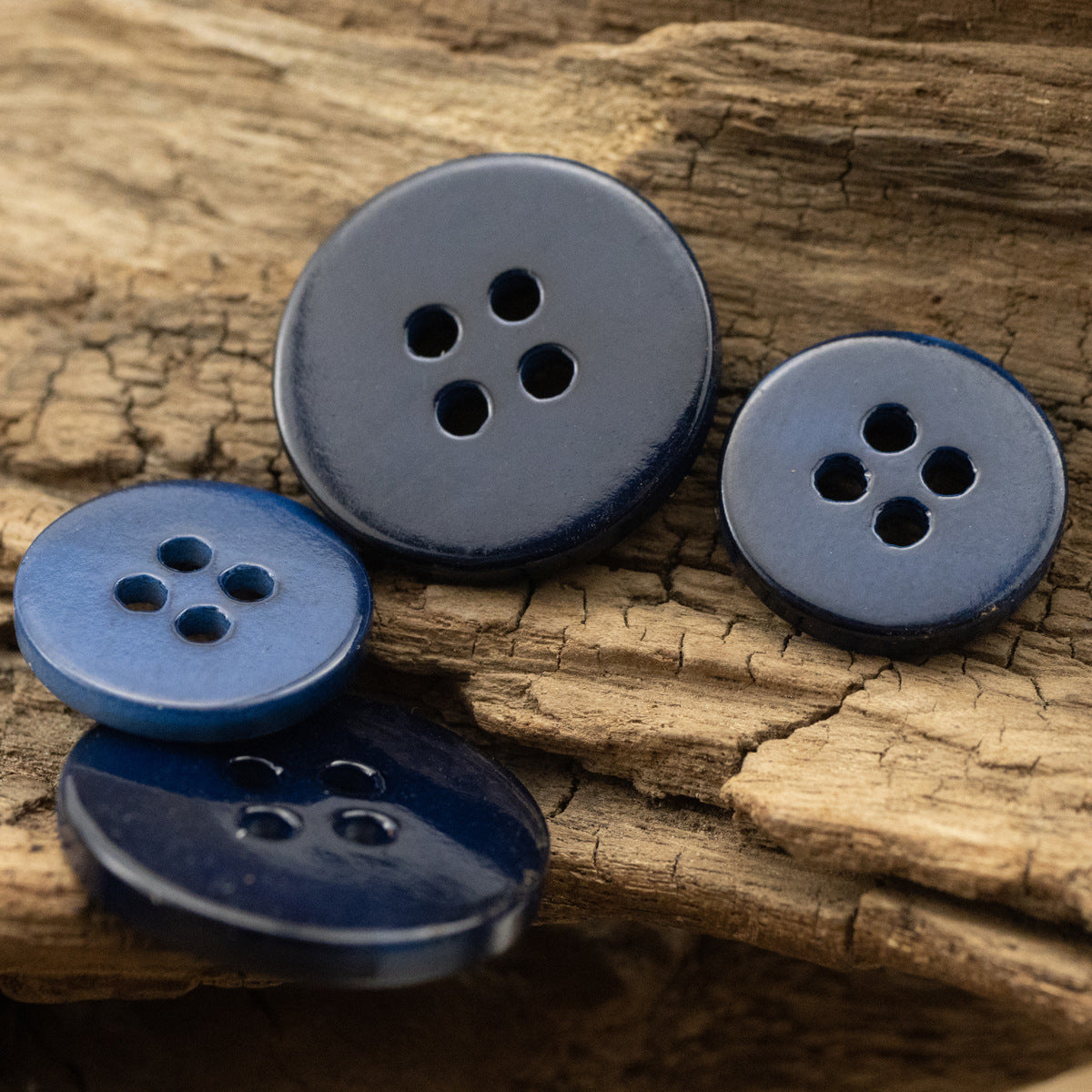 Deep blue 4-hole shirt buttons, flat round, pearl-shell style from multiple angles
