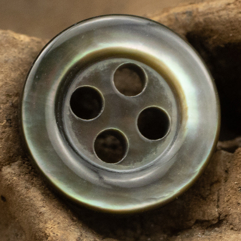 Single 11.5mm four-hole shell button, gunmetal gray with gold-toned edge
