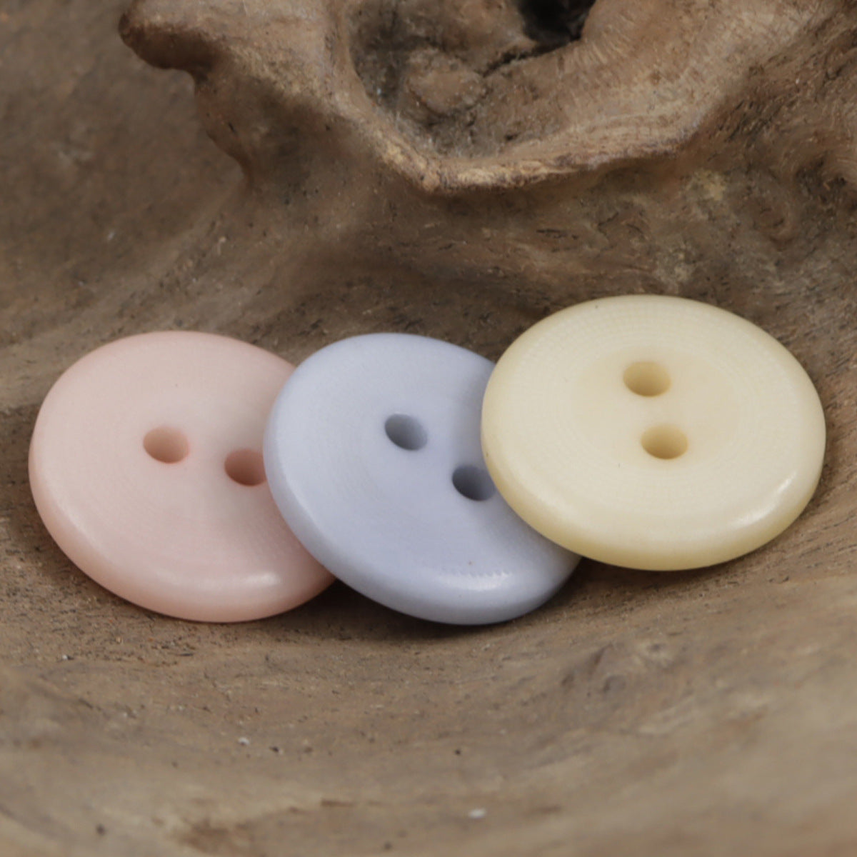 Set of round 2-hole buttons: pink, blue, and natural yellow corozo-style