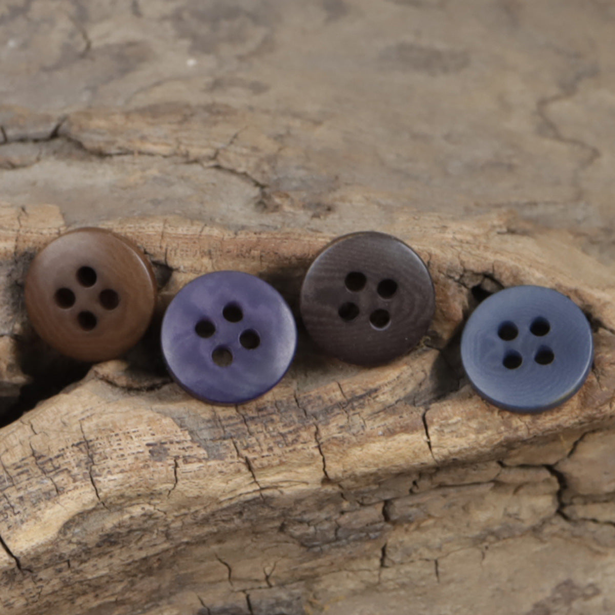 Natural fruit buttons on wood: deep purple and dark rounds with four holes