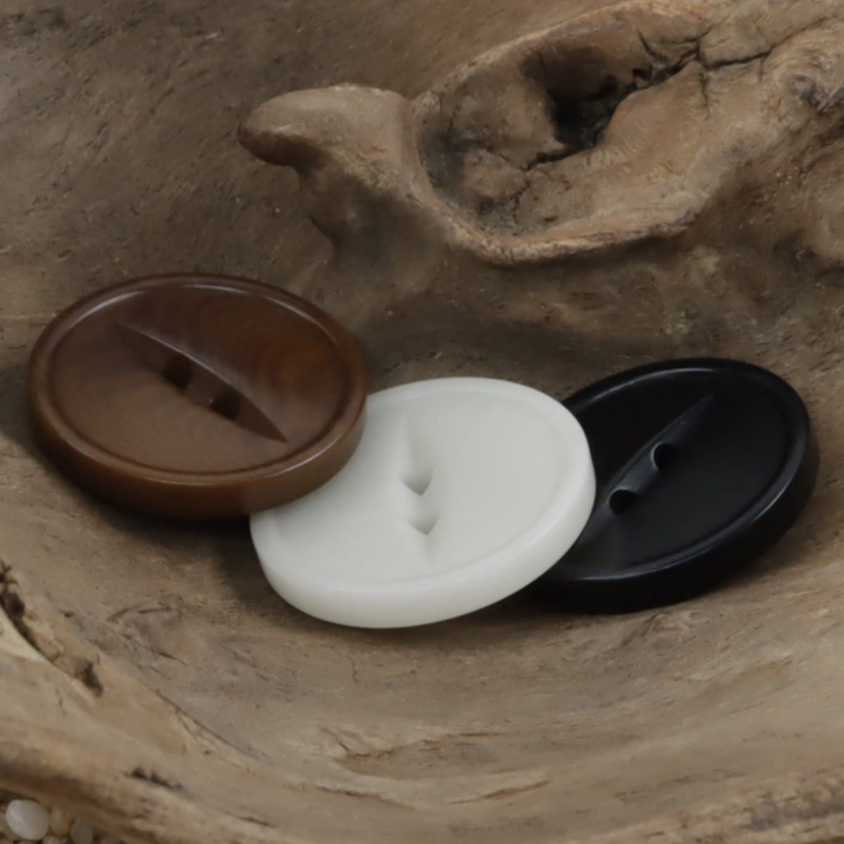 Two-hole corozo buttons in coffee, white, and black