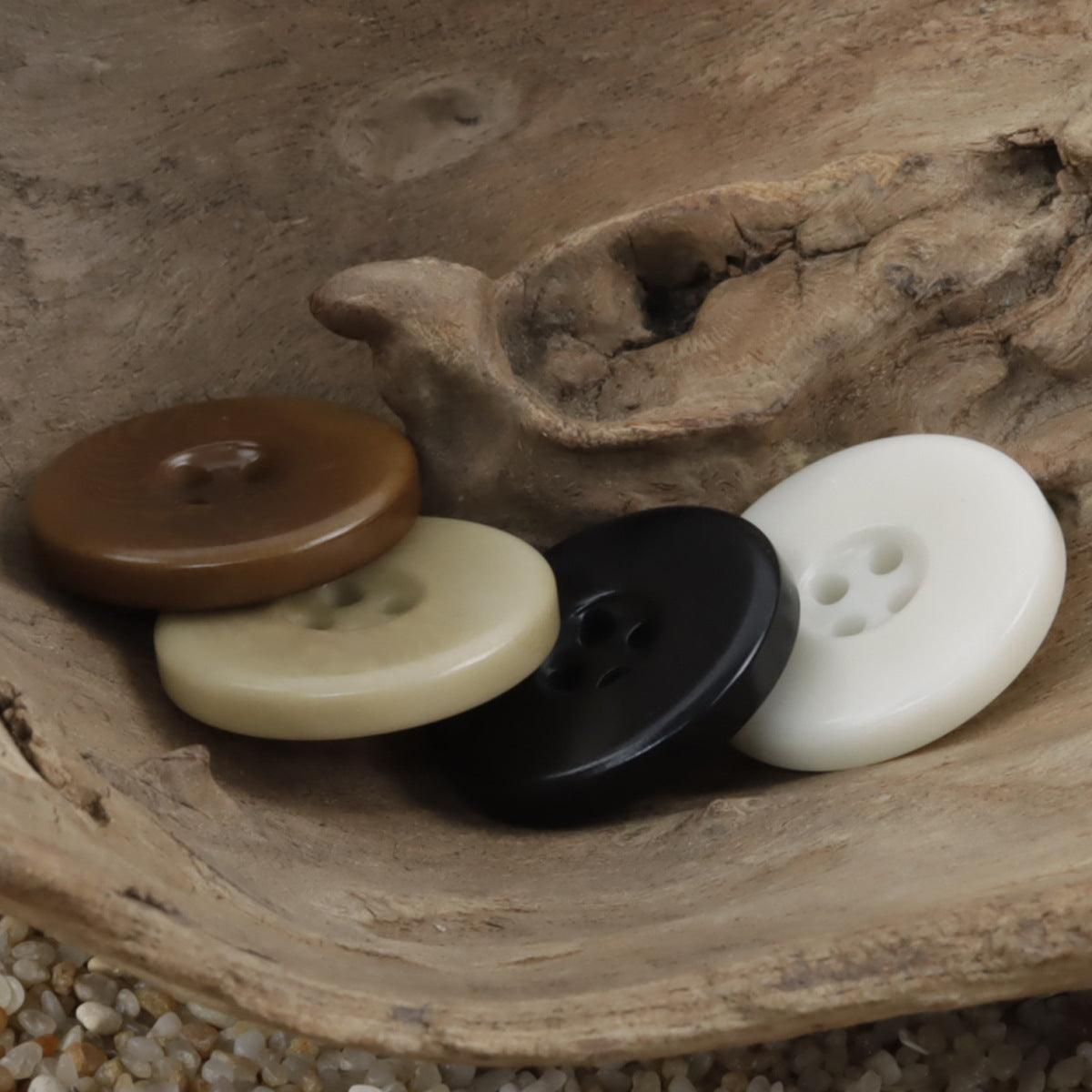 Wide border palm nut buttons with four holes in brown, cream, black, and white