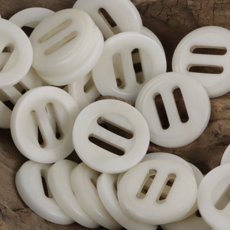 White long-eye slider buckle buttons, round with long oval slots.