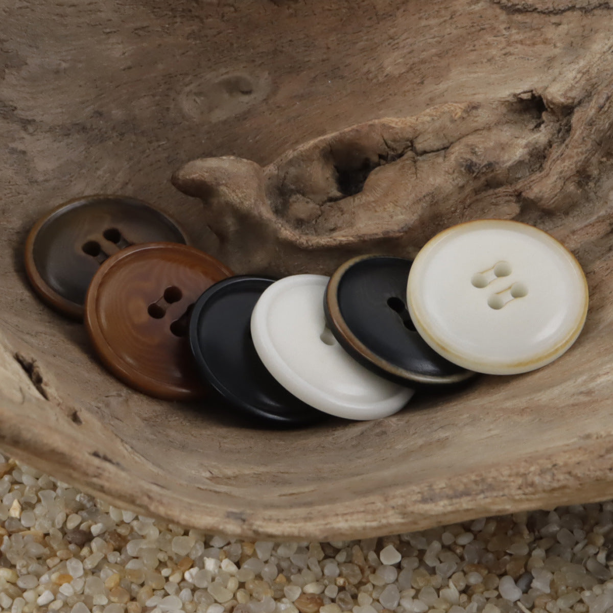 Mixed fire-burned tagua nut buttons: white, black, and brown round fronts with 4 holes