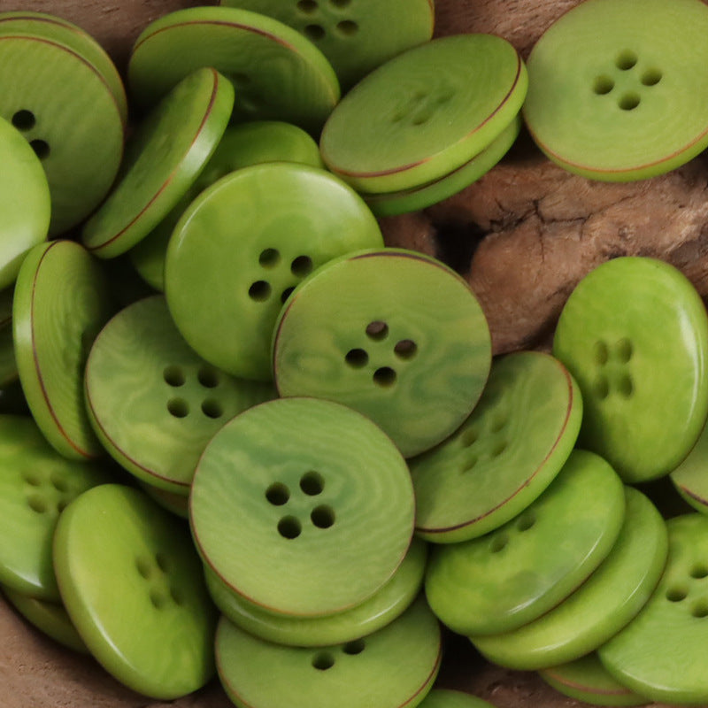 Green flat nut buttons with four holes, curved edge and rim accents