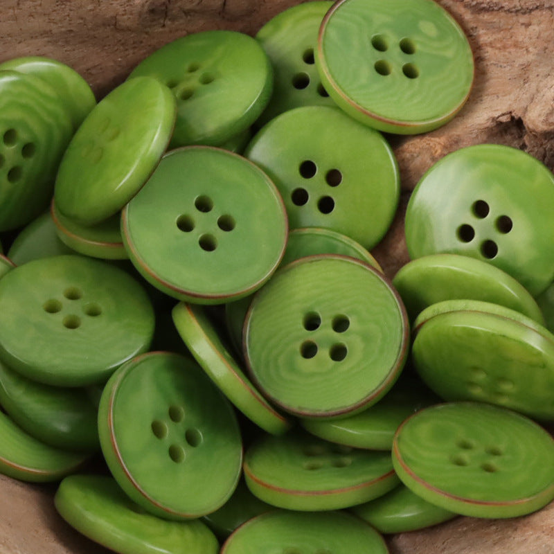 Green flat nut buttons with four holes and red-brown rim detail