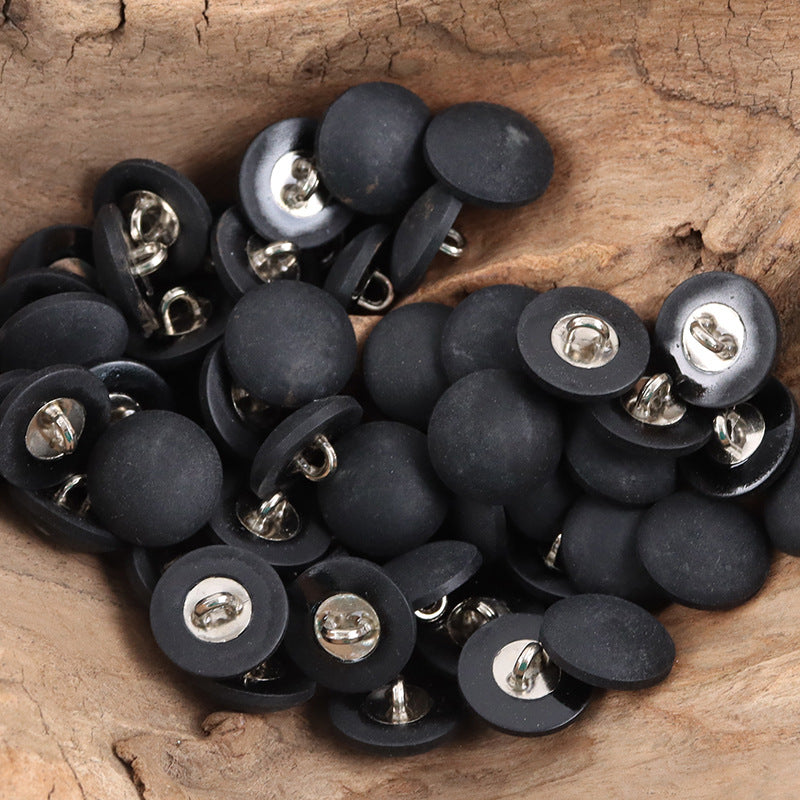 Assorted matte black suit cuff buttons with metal stems and silver backs