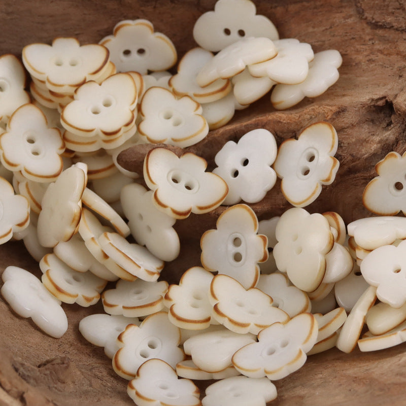 Butterfly-shaped nut buttons in cream/off-white with two-hole design