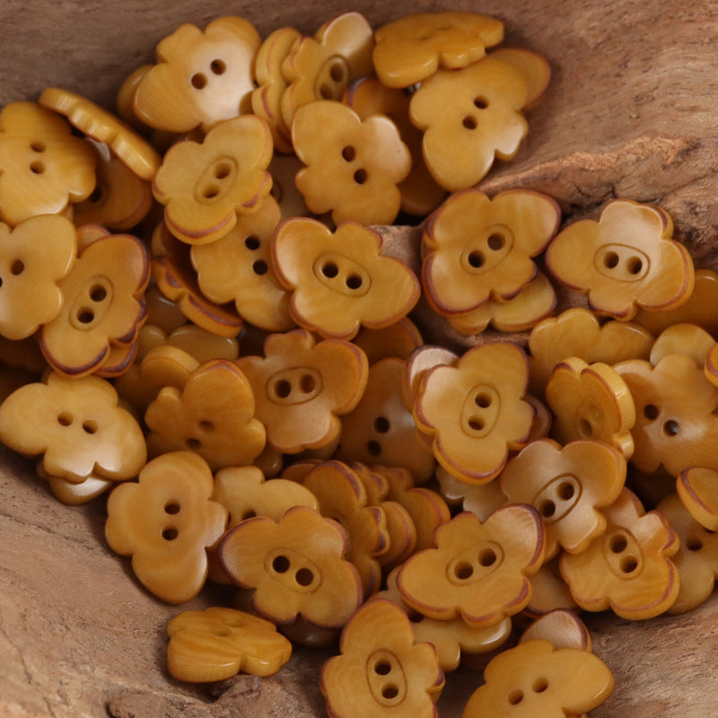 Butterfly-shaped nut buttons in warm yellow/amber tones with two-hole design