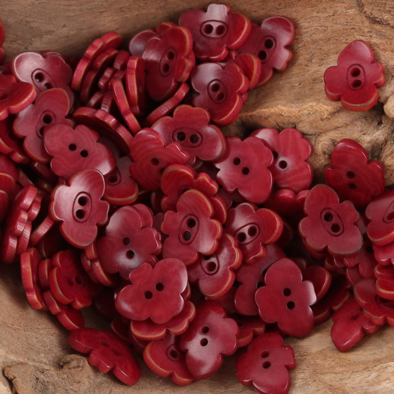 Red butterfly-shaped nut buttons with two-hole centers and grooved edges