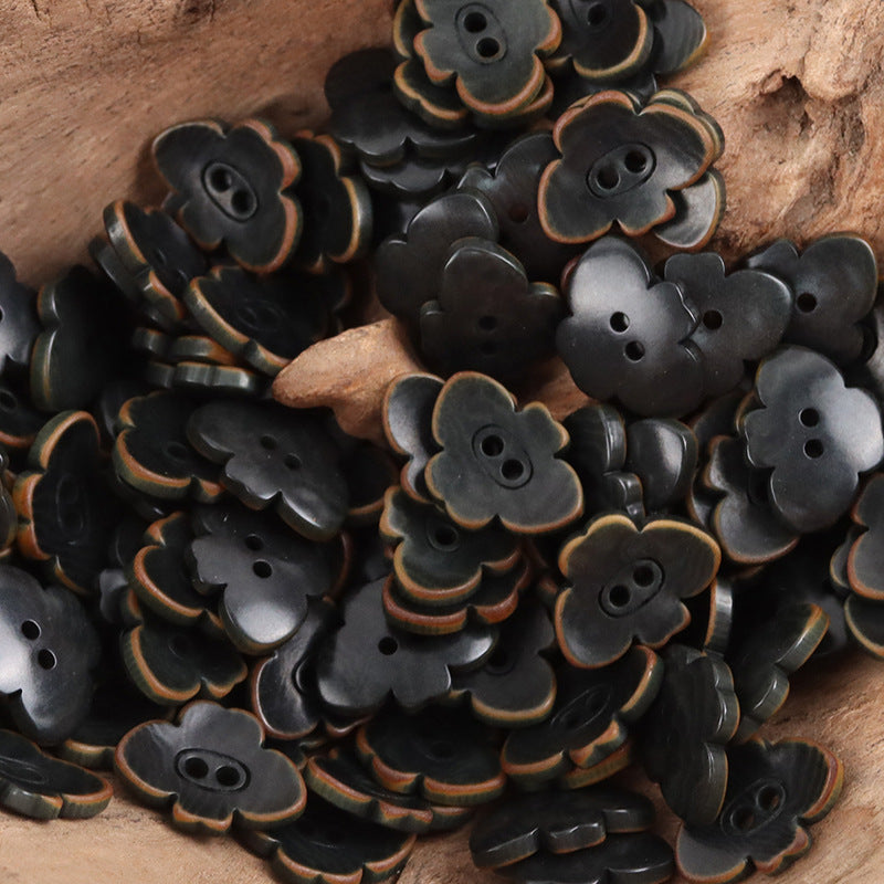 Dark gray/black butterfly-shaped nut buttons with two-hole centers and ridged edges