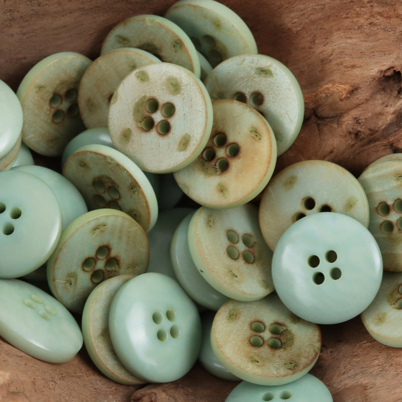 Light green round 4-hole nut buttons with leaf pattern and natural speckles