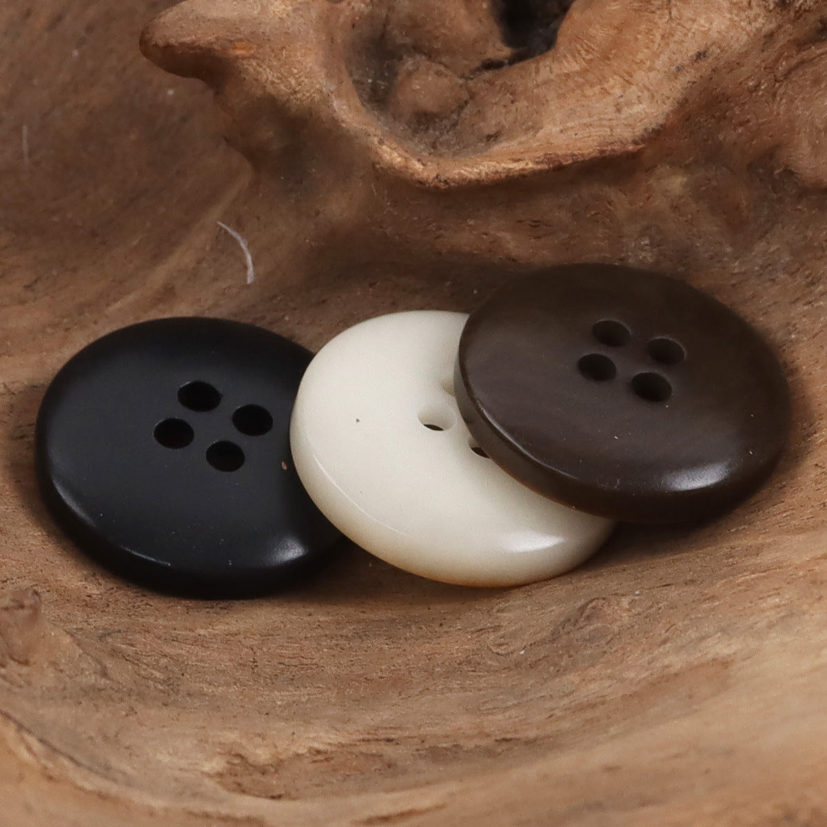 Nut-style buttons in black, beige, and dark brown, each showing 4-hole face