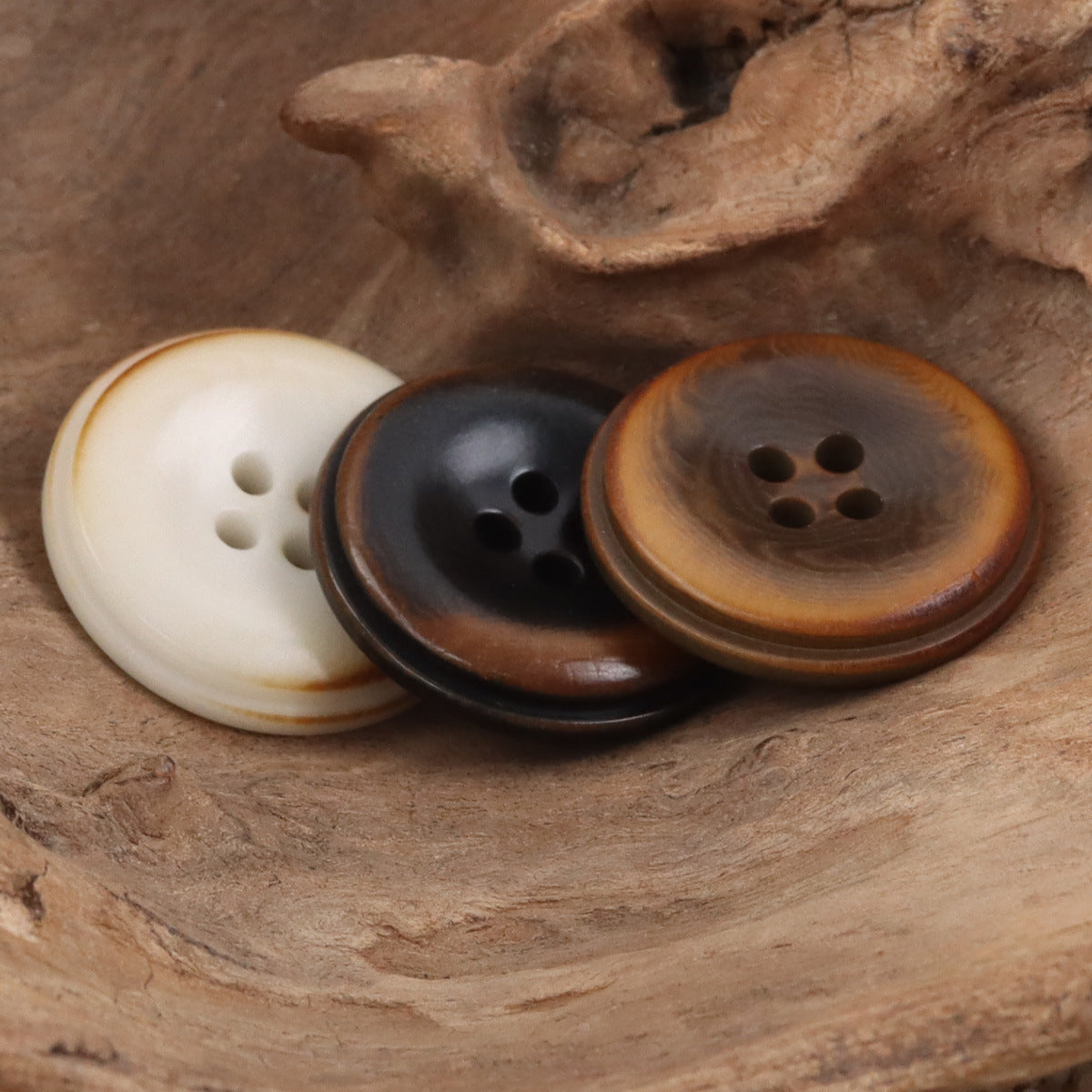 Set of three round buttons: white, black, and brown, four-hole design