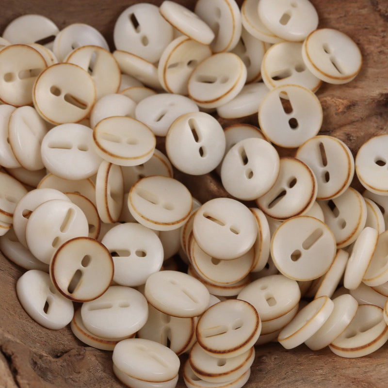 Cream palm fruit buttons with exclamation mark cutout, round, 2-hole style look.