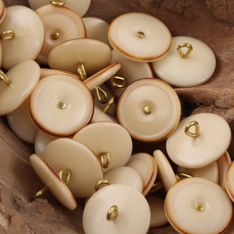 Beige tagut nut buttons with golden shanks, burnt-edge rim, round 1-hole design