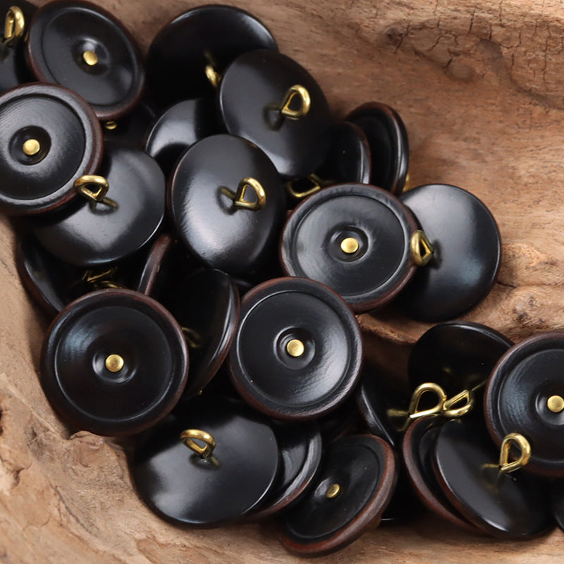 Black tagut nut buttons with golden shanks, burnt-edge rim, round 1-hole design