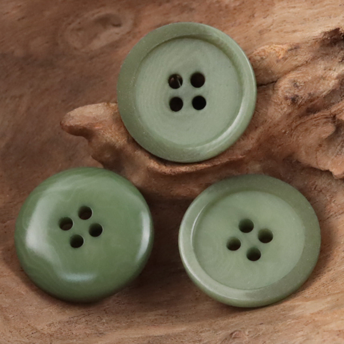 Light green Tagut buttons with 4 holes, round flat design