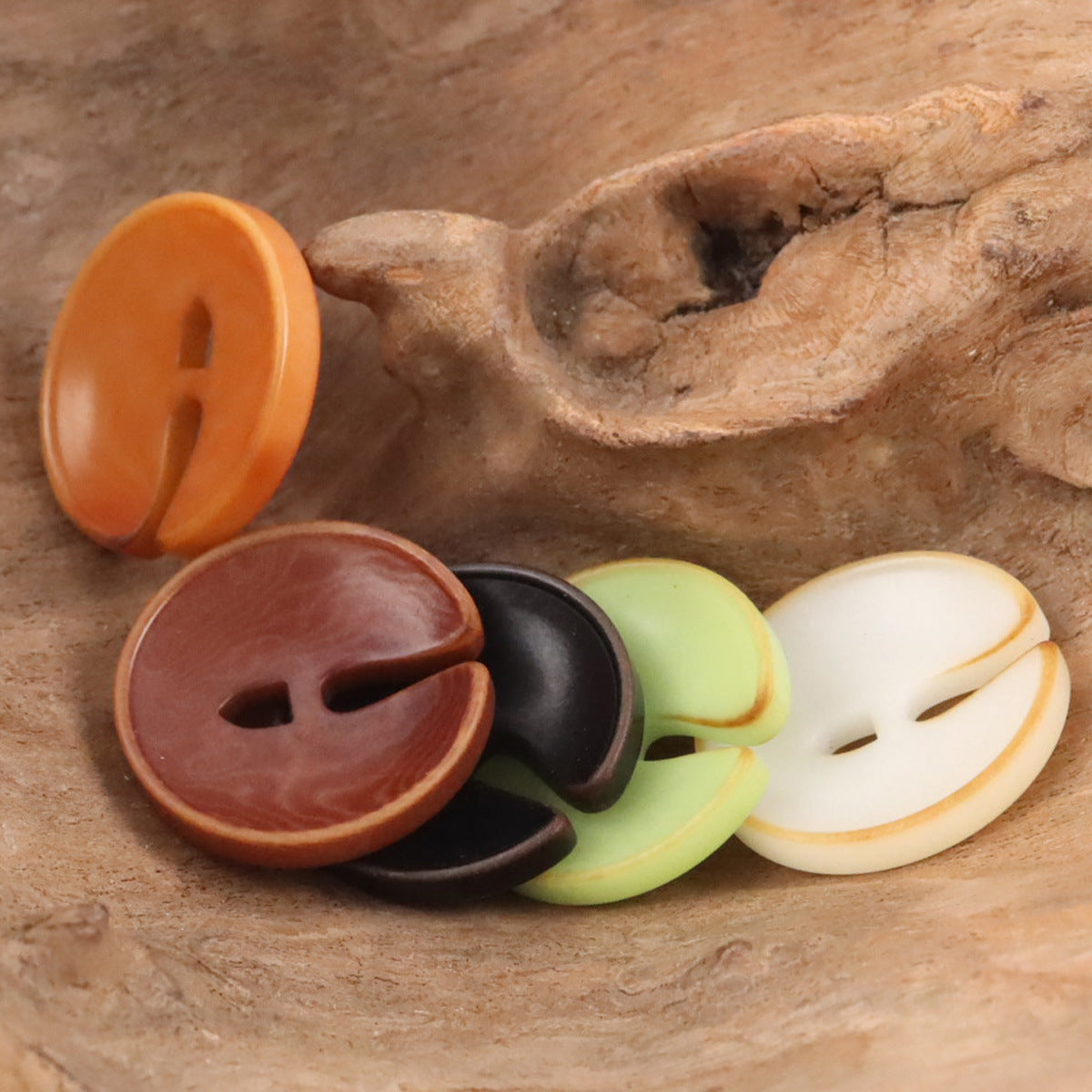 Pac-Man tagua nut buttons in orange, maroon, black, green, and cream