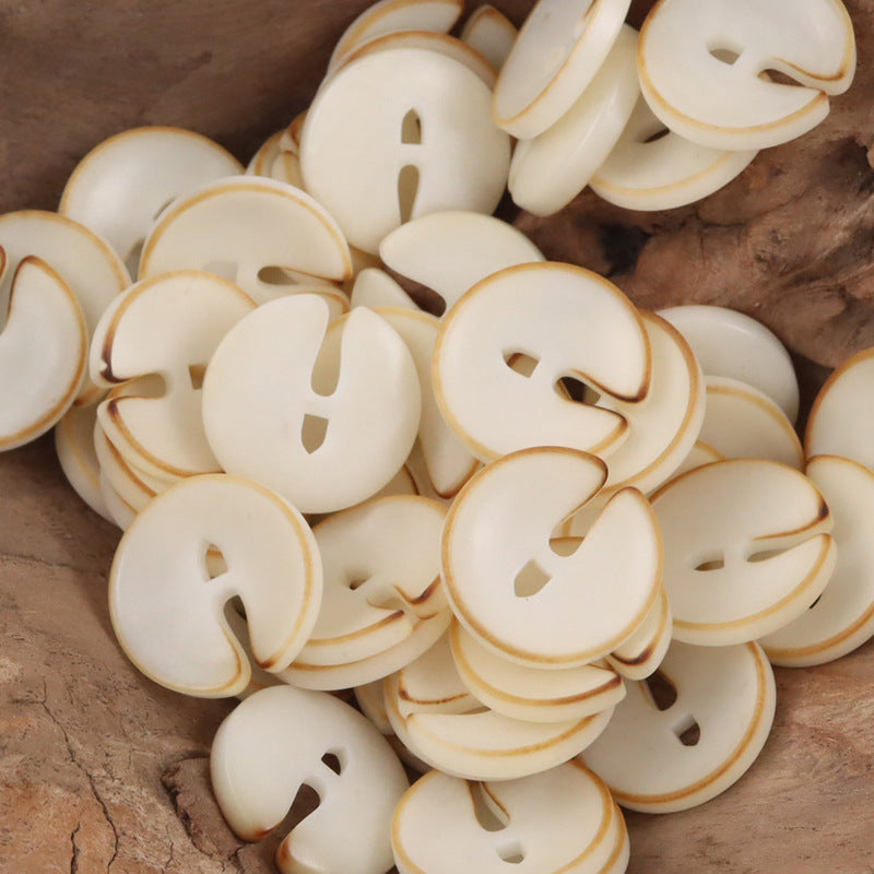 Pac-Man tagua nut buttons, cream color with cutout eyes and mouth