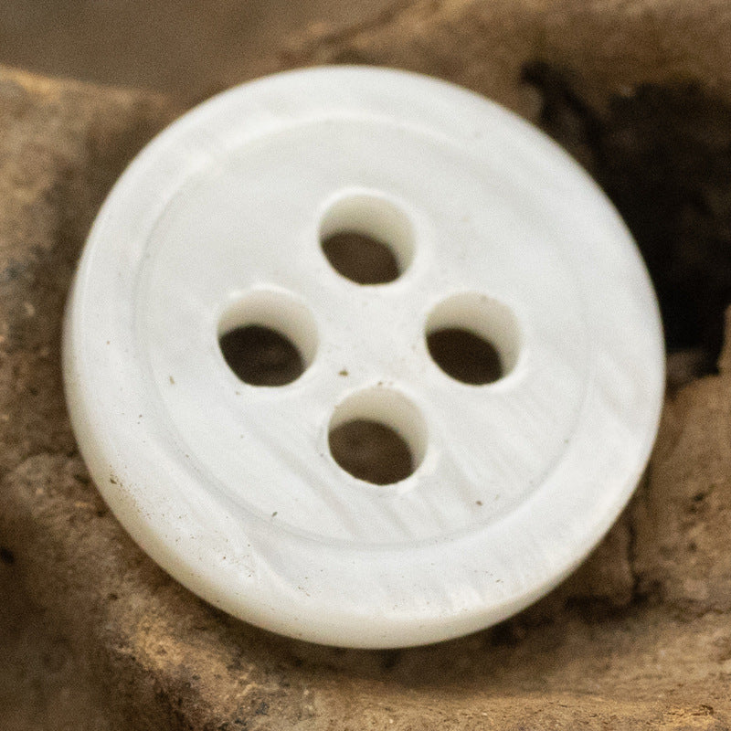 Round 11.5mm shell button, 4-hole—white/beige with natural mottling (single button shown).