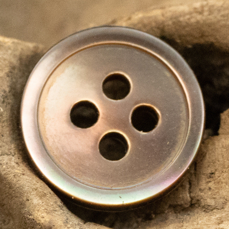 Round 11.5mm shell button, 4-hole—medium gray with bronze tint around the rim.