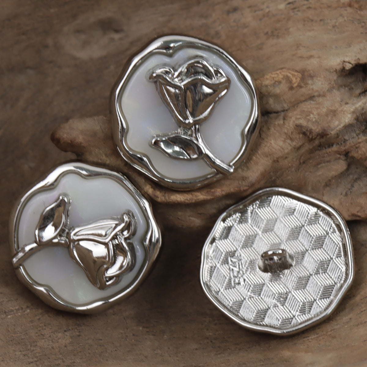 Set of silver rose decorative metal buttons, one with floral rose front and checker back