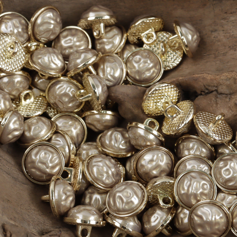 Chinese-style buttons with champagne/gold-tone rims, light pearl domes, and textured metal backs